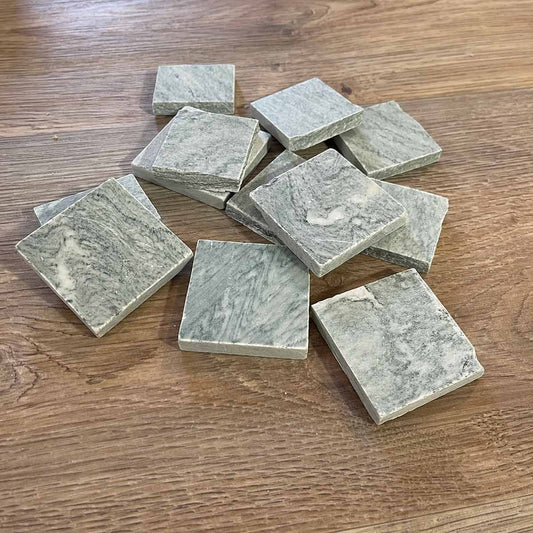 Marmo verde cipollino green marble tagliato in quadrotti su un tavolo in legno