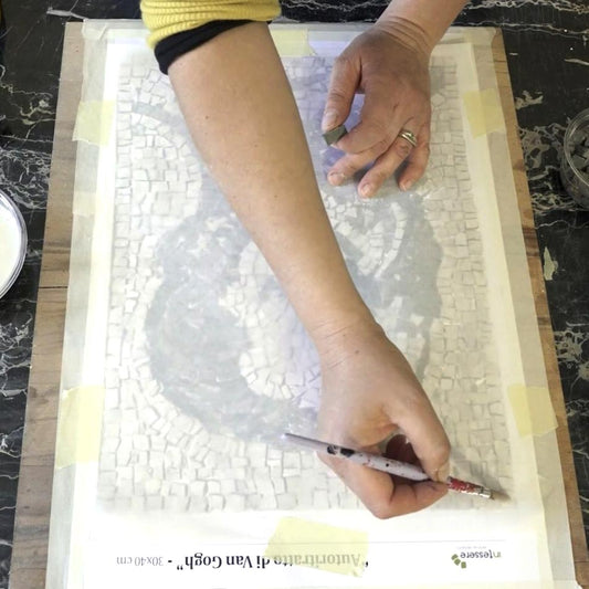 mano mentrer compone un mosaico usando la tecnica indiretta