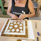 A woman is creating a colorful Moroccan Ceramic mosaic in a Mosaic School