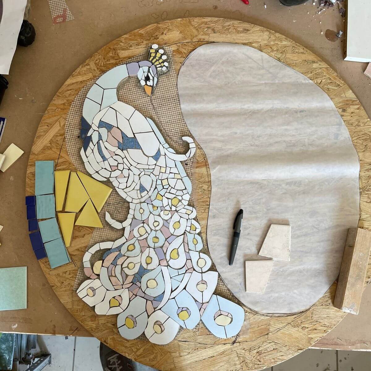 Progetto di mosaico ceramico Trencadís con sagoma di pavone in lavorazione durante il corso presso la scuola In Tessere Narni.