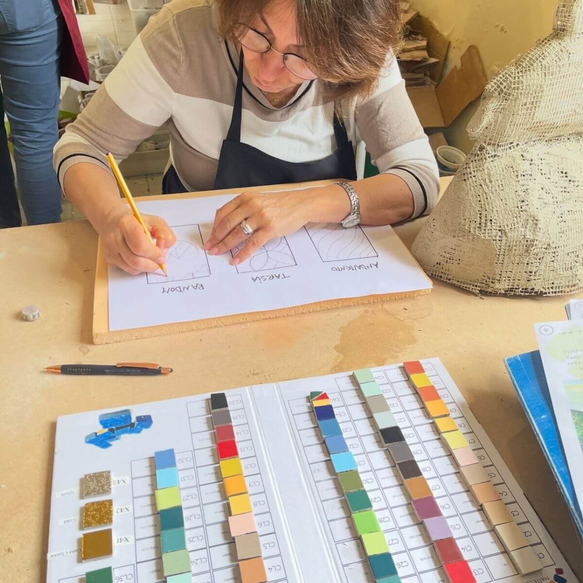 Allieva progetta il disegno preparatorio per il mosaico ceramico Trencadís con tessere colorate.