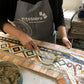Alunna mentre rifinisce un mosaico romano creato durante il corso di mosaico romano In tessere