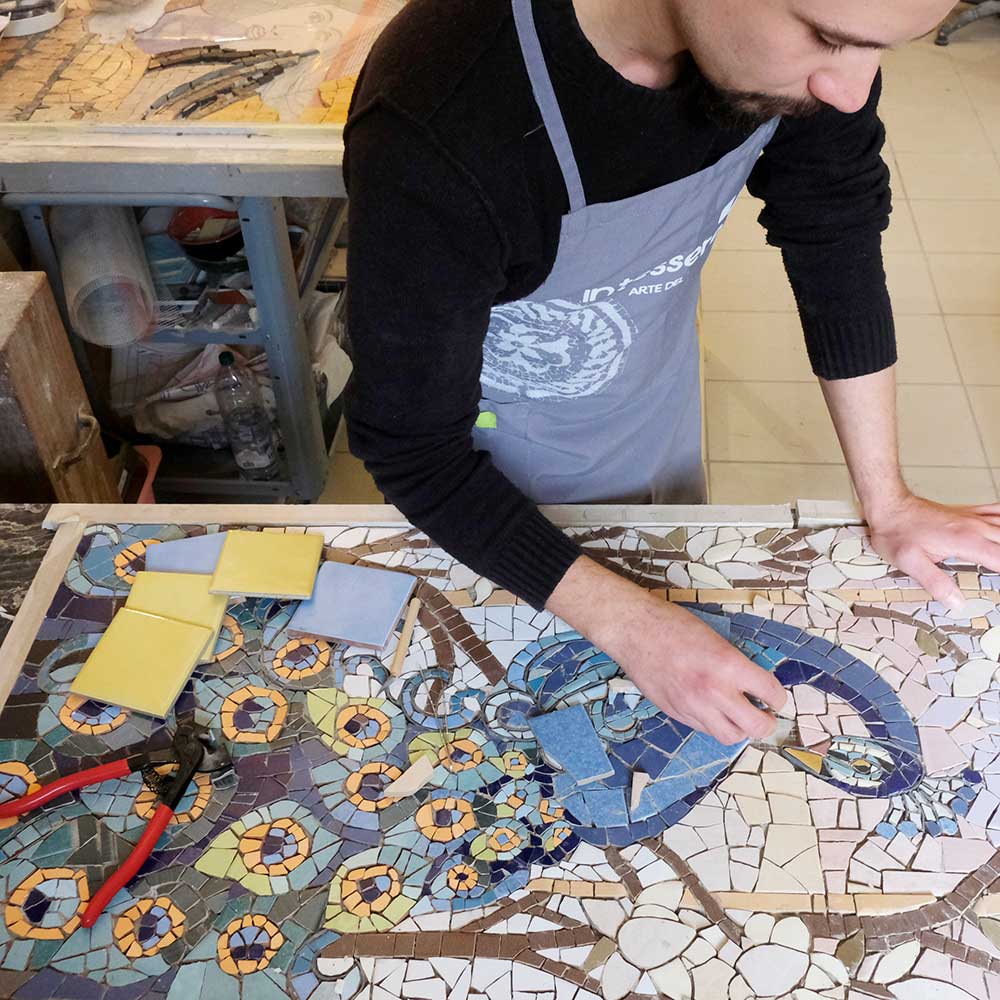 studente della scuola di mosaico In tessere mentre studia ed esegue un mosaico colorato stile trancadis