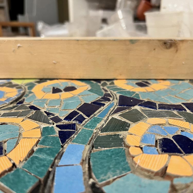 Livellazione del mosaico trencadis con un bastone di legno